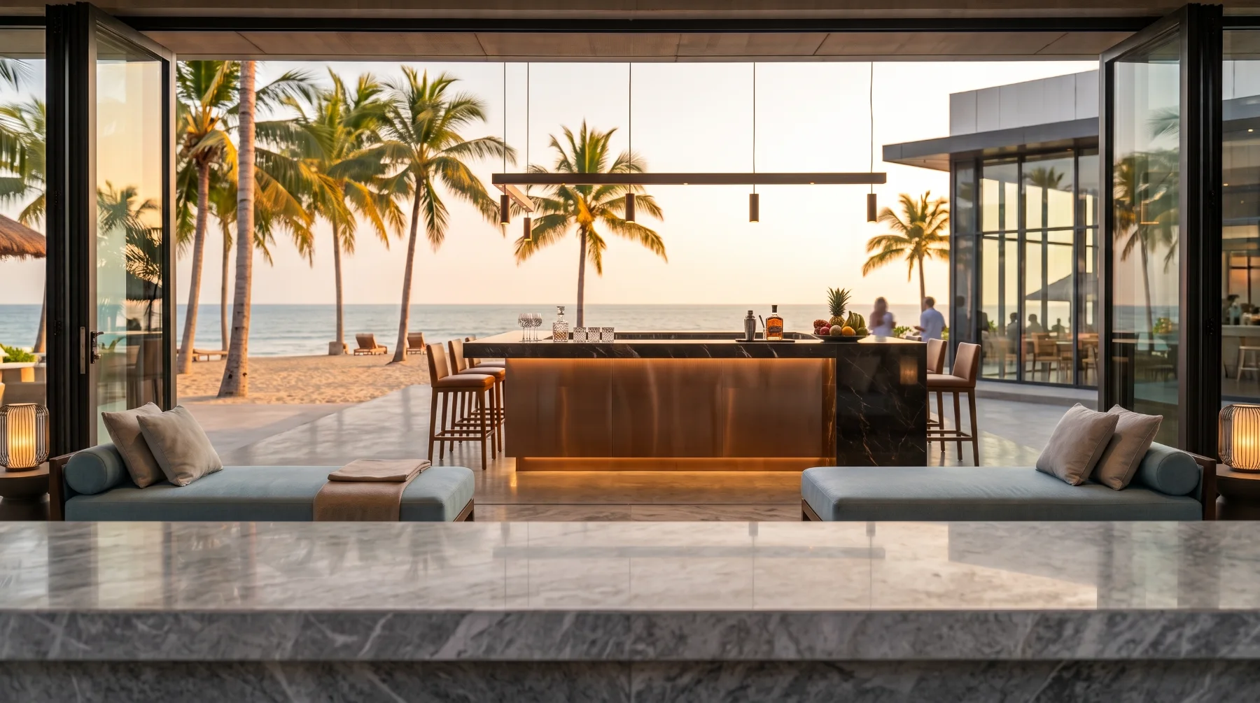 A marble bar top looking out to palm trees and the ocean at sunset.