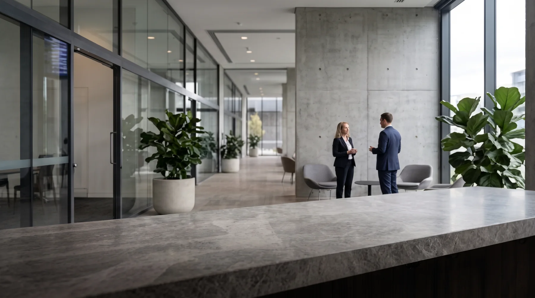 A stone reception counter in a light-filled office lobby.